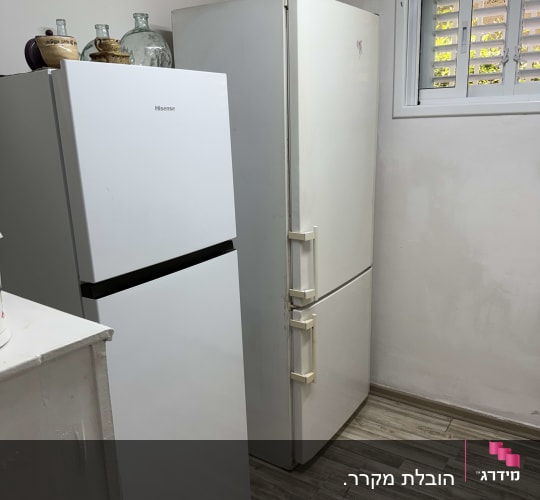 שני מקררים בחדר עם רצפת עץ